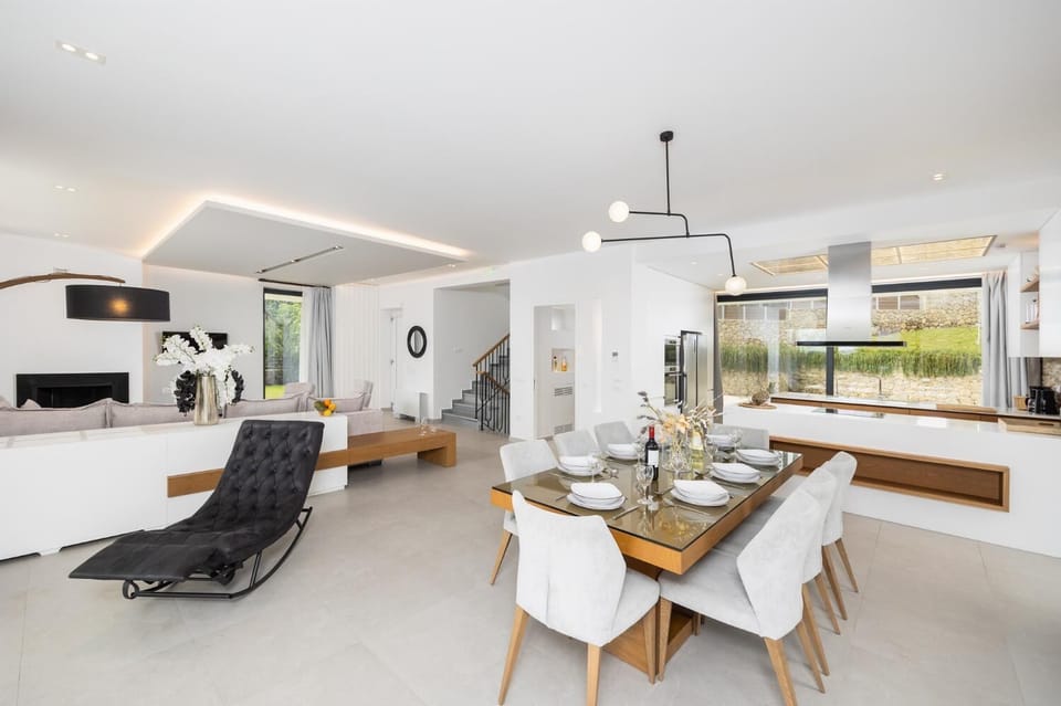 Open-plan living room on first floor with sofa, dining area, kitchen, ornamental fireplace, A/C, WiFi internet, and satellite TV