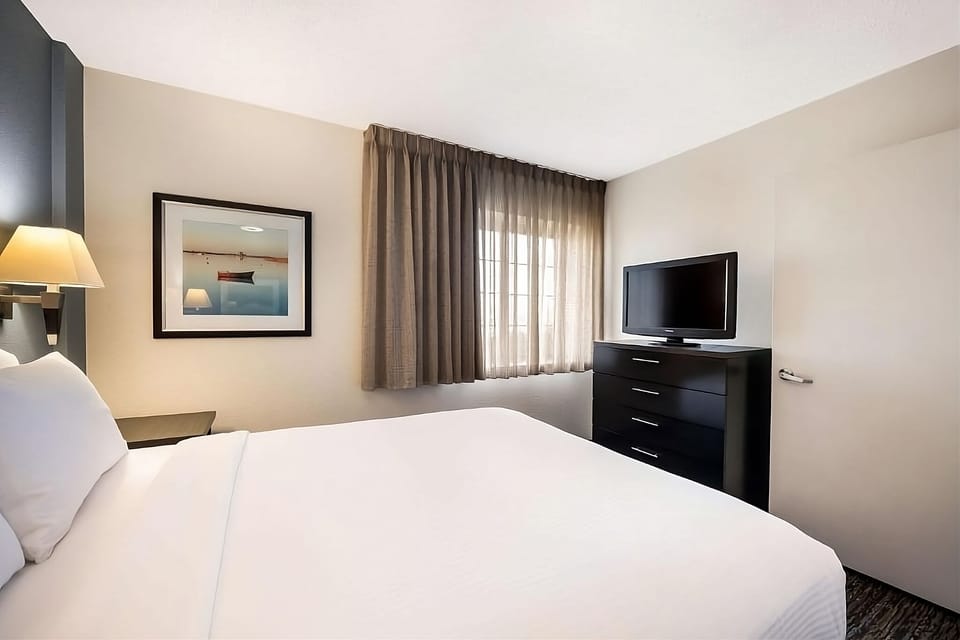 Recharge in a calm room with TV and blackout drapes.