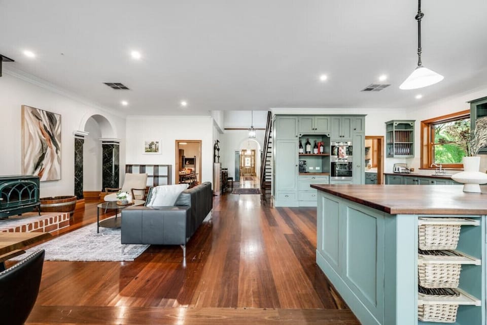 With its sleek wooden floors and generous seating area, this living room offers a perfect blend of comfort and style, ideal for hosting or relaxing together.