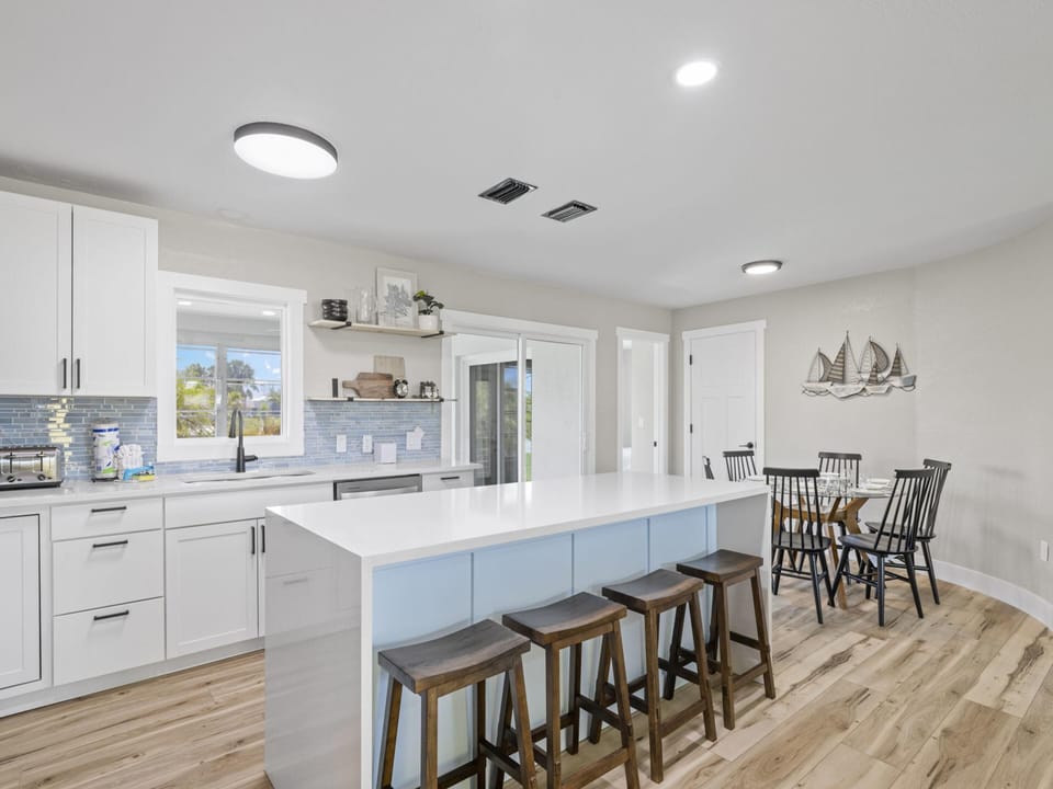 Fully Equipped Kitchen with Stainless Steel Appliances and Breakfast Bar Seating for Four