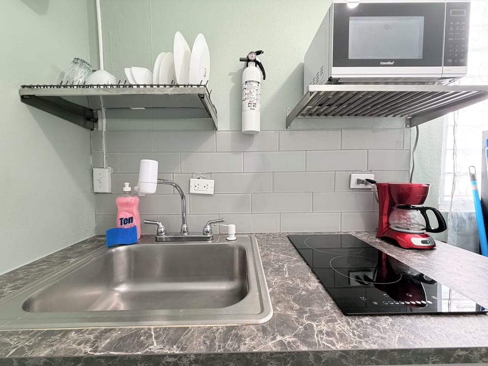Kitchen with 2 burn stove, microwave, refrigerator, coffee maker.