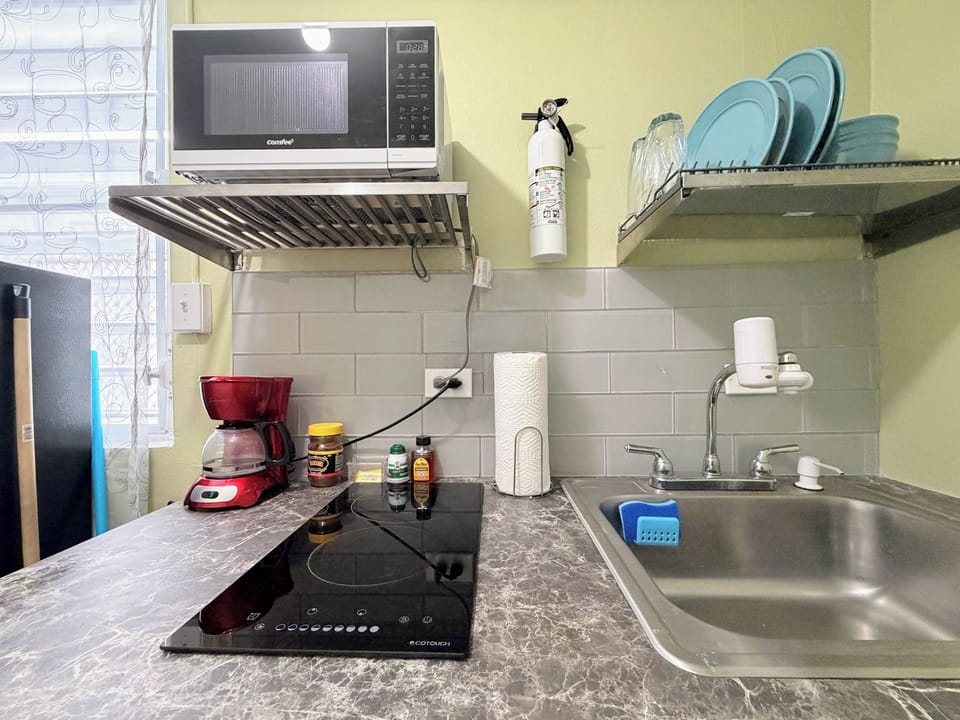 Kitchenette with 2 burner stove, microwave, refrigerator and cooking utensils