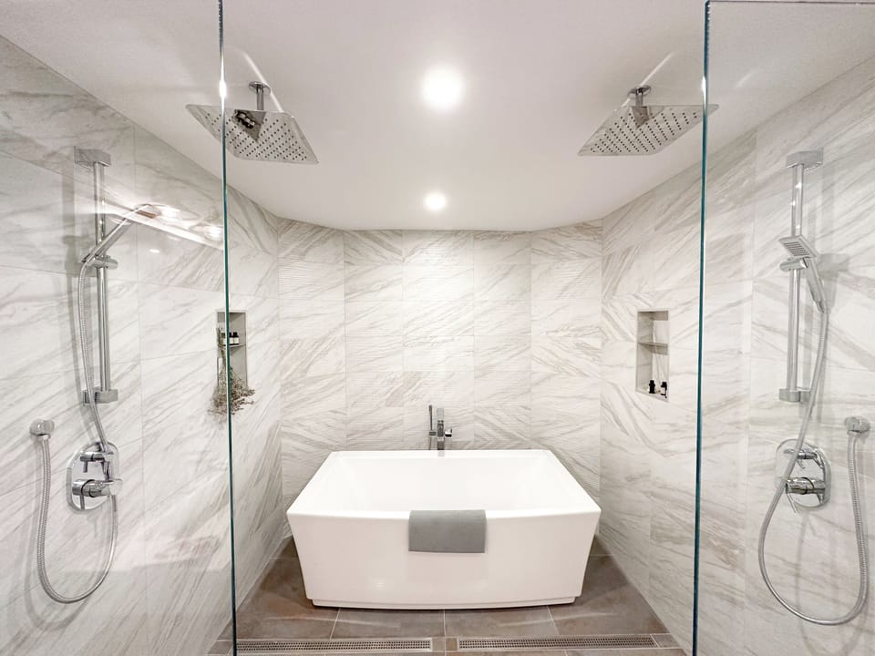Unwind in your luxurious marble sanctuary with dual rainfall showers and a soaking tub for ultimate relaxation.