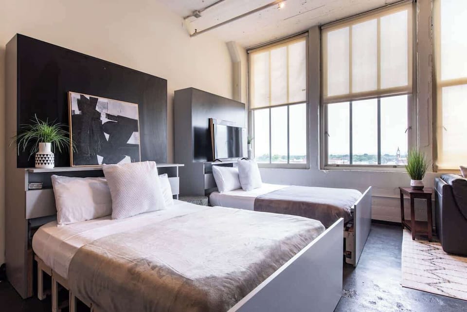 Welcome to our lovely loft that features almost 14ft tall windows overlooking West Louisville. 
Pictured are Beds #2 and #3 (both can be closed to optimize even more communal, entertaining space)