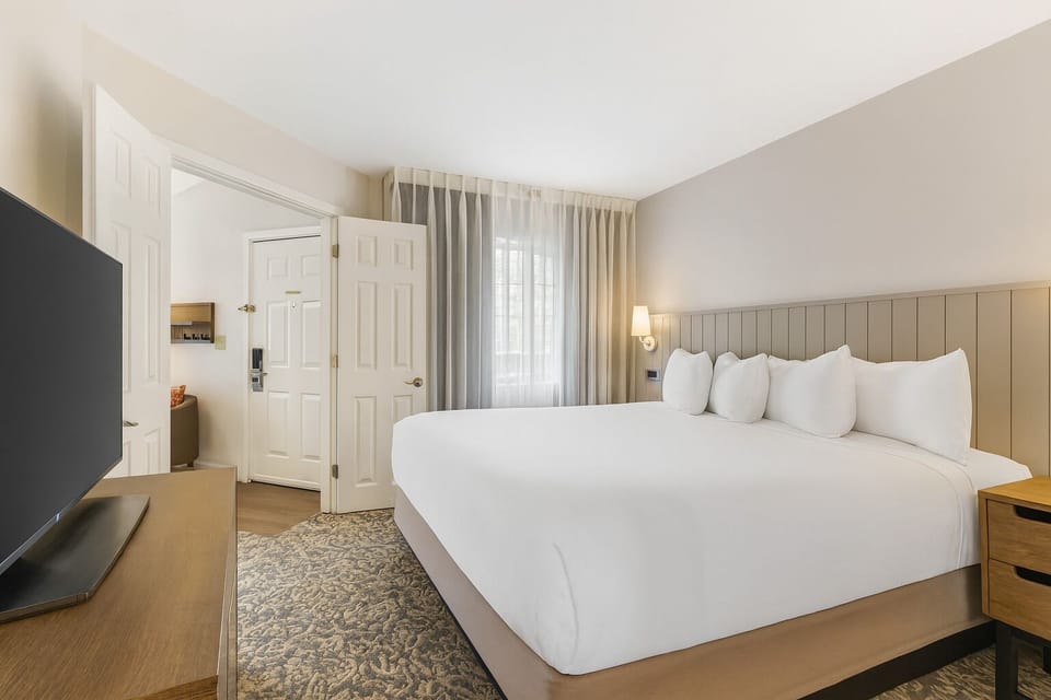 Unwind in a plush king bed with soft, calming light.