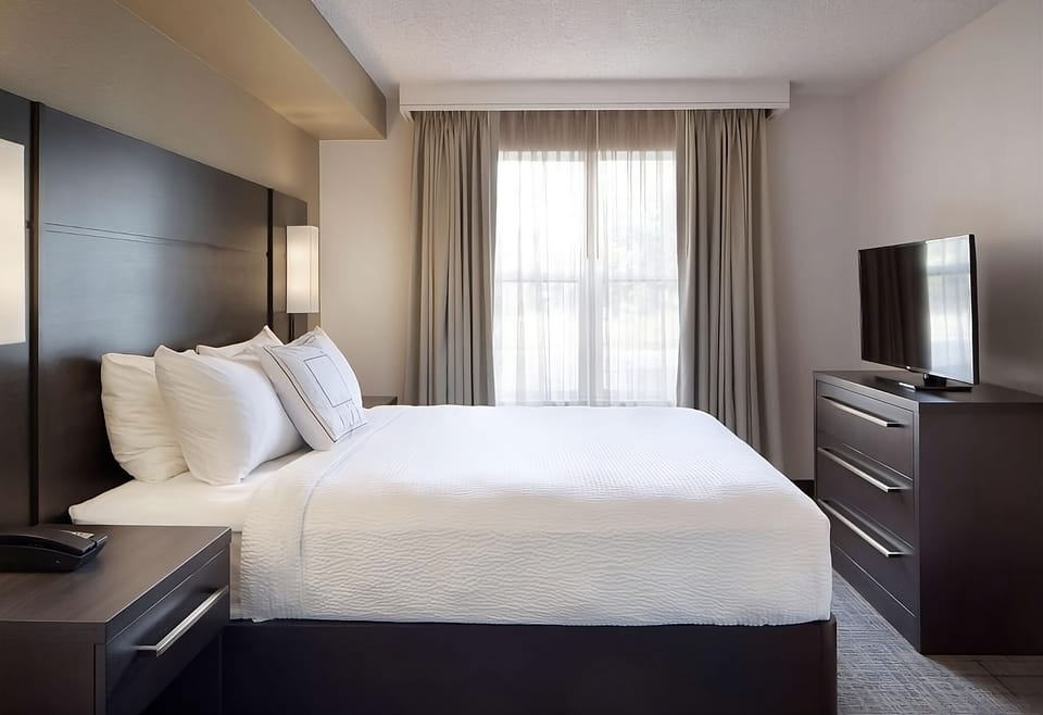 Sink into a serene bed under warm, welcoming lights.