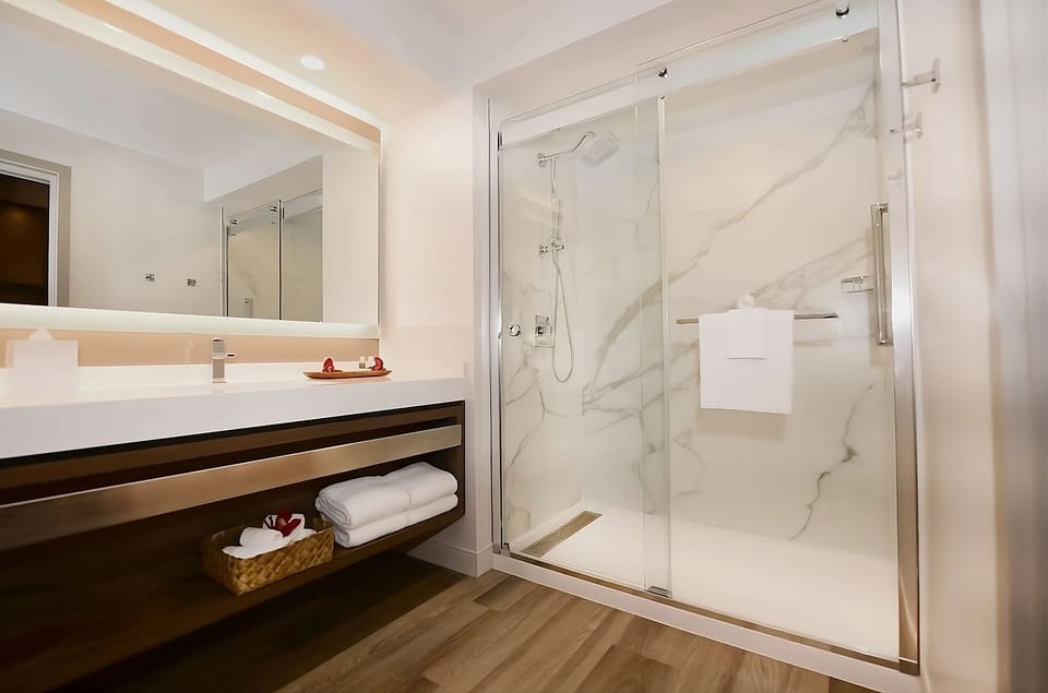 Refresh under a spacious rainfall shower in sleek marble style.