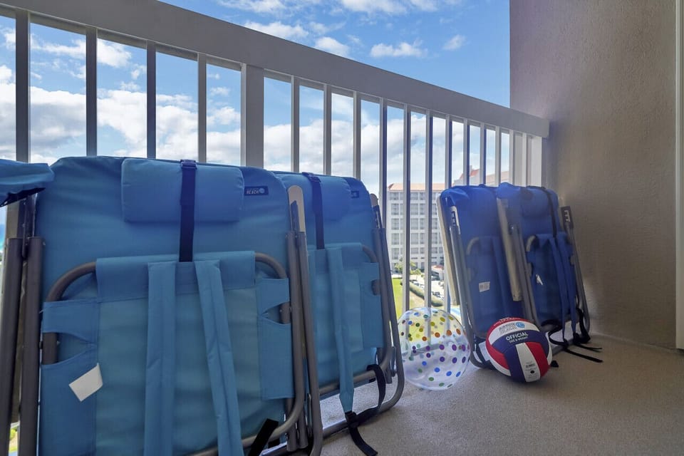 Beach-ready condo: Chairs, umbrella, toys.