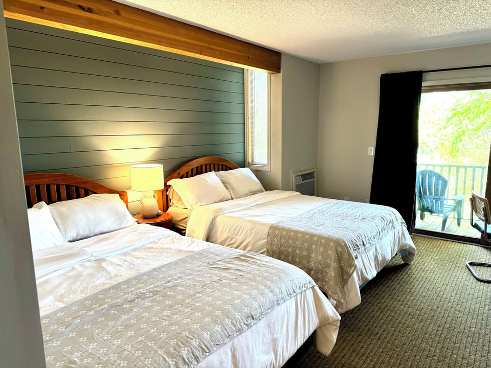 Hotel style bedroom with 2 queen beds, full bathroom and kitchenette.