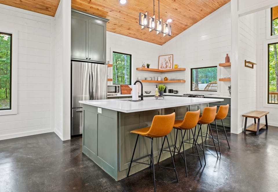 Experience the charm of this well-lit kitchen, featuring sleek appliances and a central island that doubles as a casual dining spot.