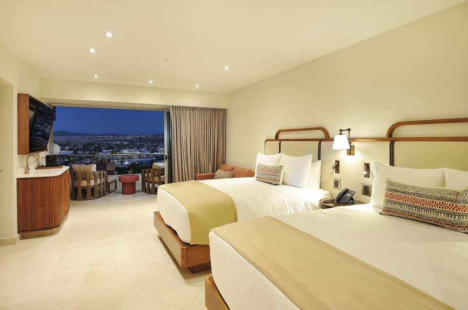 Unwind at dusk as city lights glow beyond curtains.