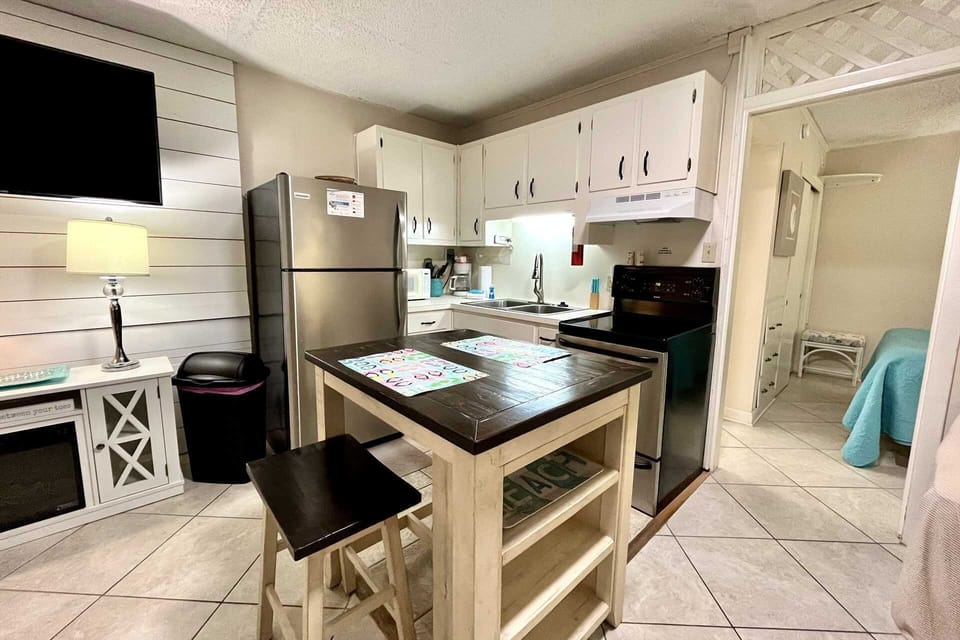 Another view of the kitchen - stainless steel appliances and island for meal prep.