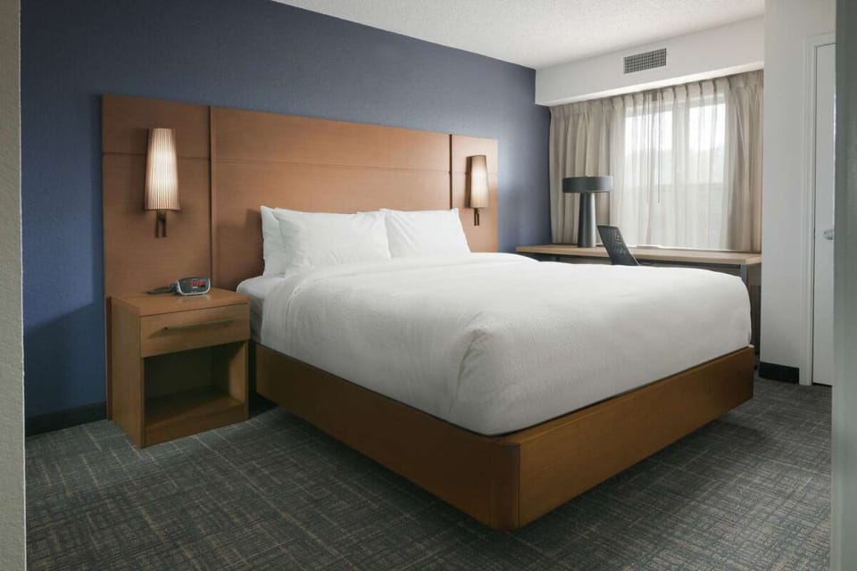 Unwind in a crisp, quiet bedroom with soft lighting.