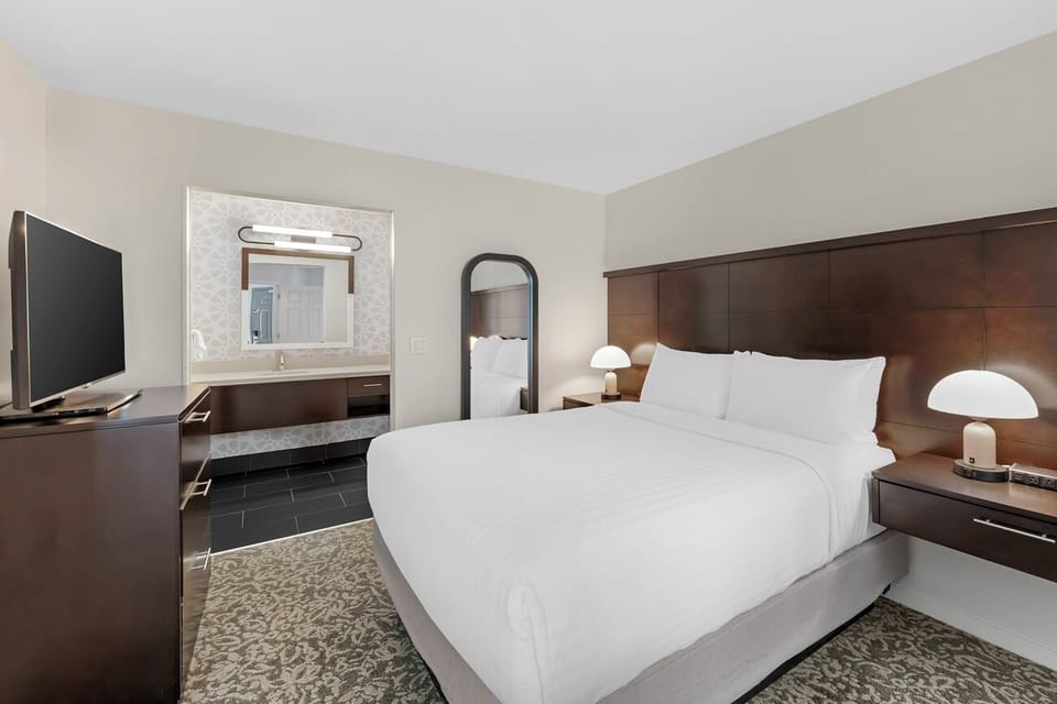 Unwind on crisp linens with convenient TV and vanity.