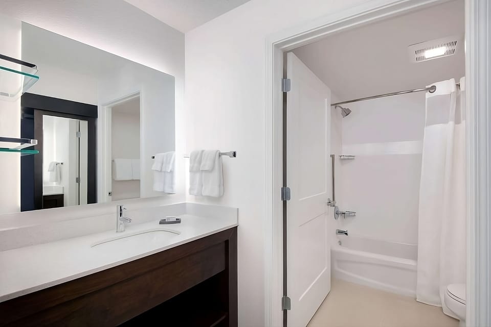 Refresh easily in a spotless bath with bright vanity lighting.