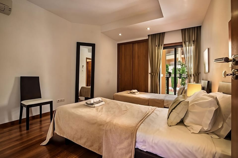 Wake up to balcony daylight in this airy twin bedroom.