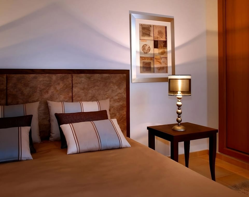 Drift off in a serene suite with cozy bedside glow.