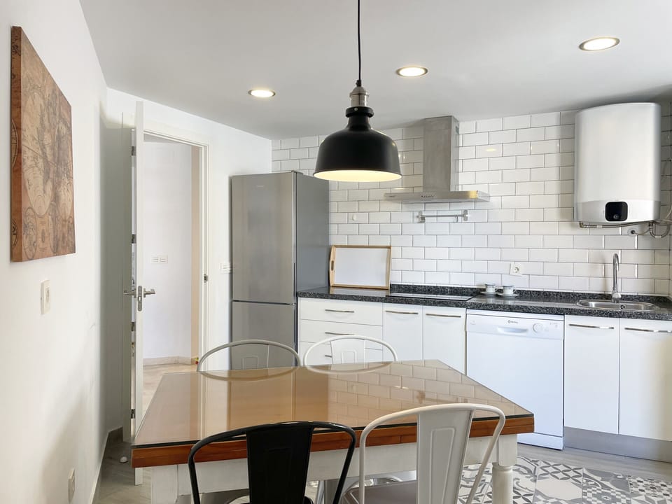 Comfortable and functional kitchen, with 4-seater table, refrigerator, dishwasher and stove
