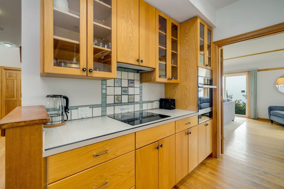 Kitchen with induction stovetop with specialty pans provided, Dishwasher, microwave, Oceanview, access to the living area.