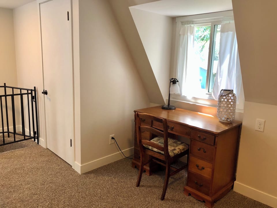 The upstairs common area is acquired with a desk and pullout bed.
