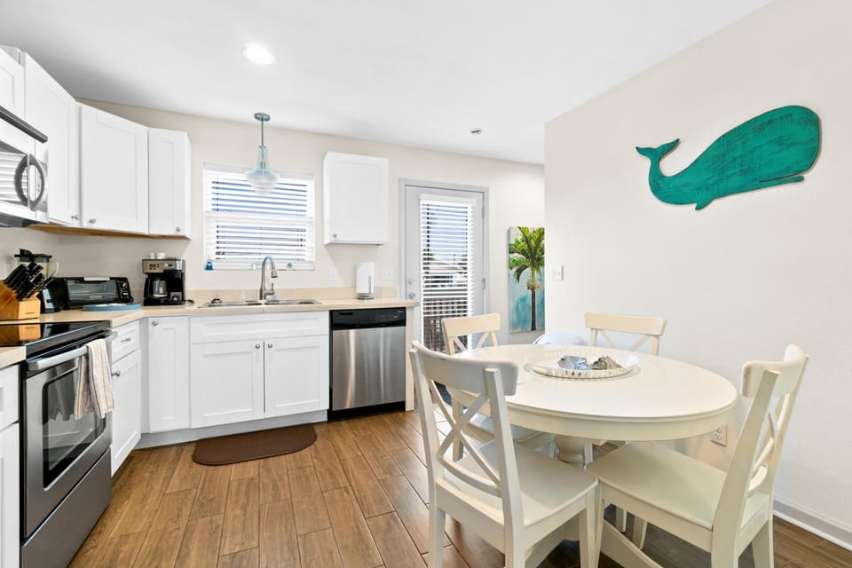 Your bright coastal kitchen welcomes you with modern appliances and charming dining space, perfect for morning coffee or family meals.