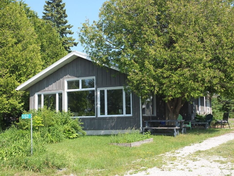 Front of cottage and shaded picnic and seating areas