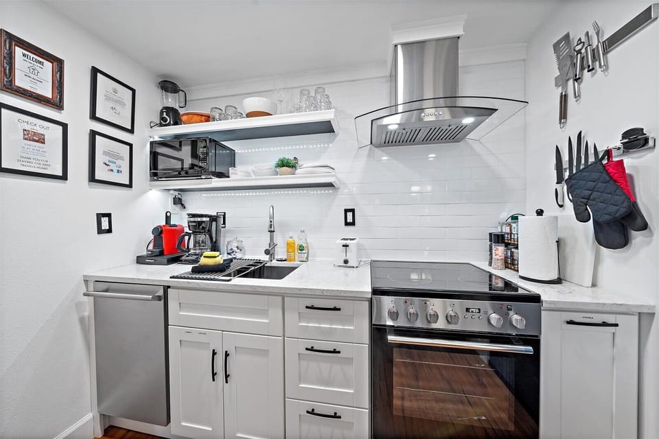 Stocked with spices, olive oil, dishes, silverware, baking pans, mixer, blender, toaster, microwave