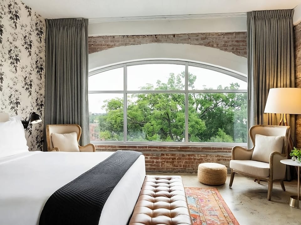 Wake slowly to treetop views through a grand arched window.