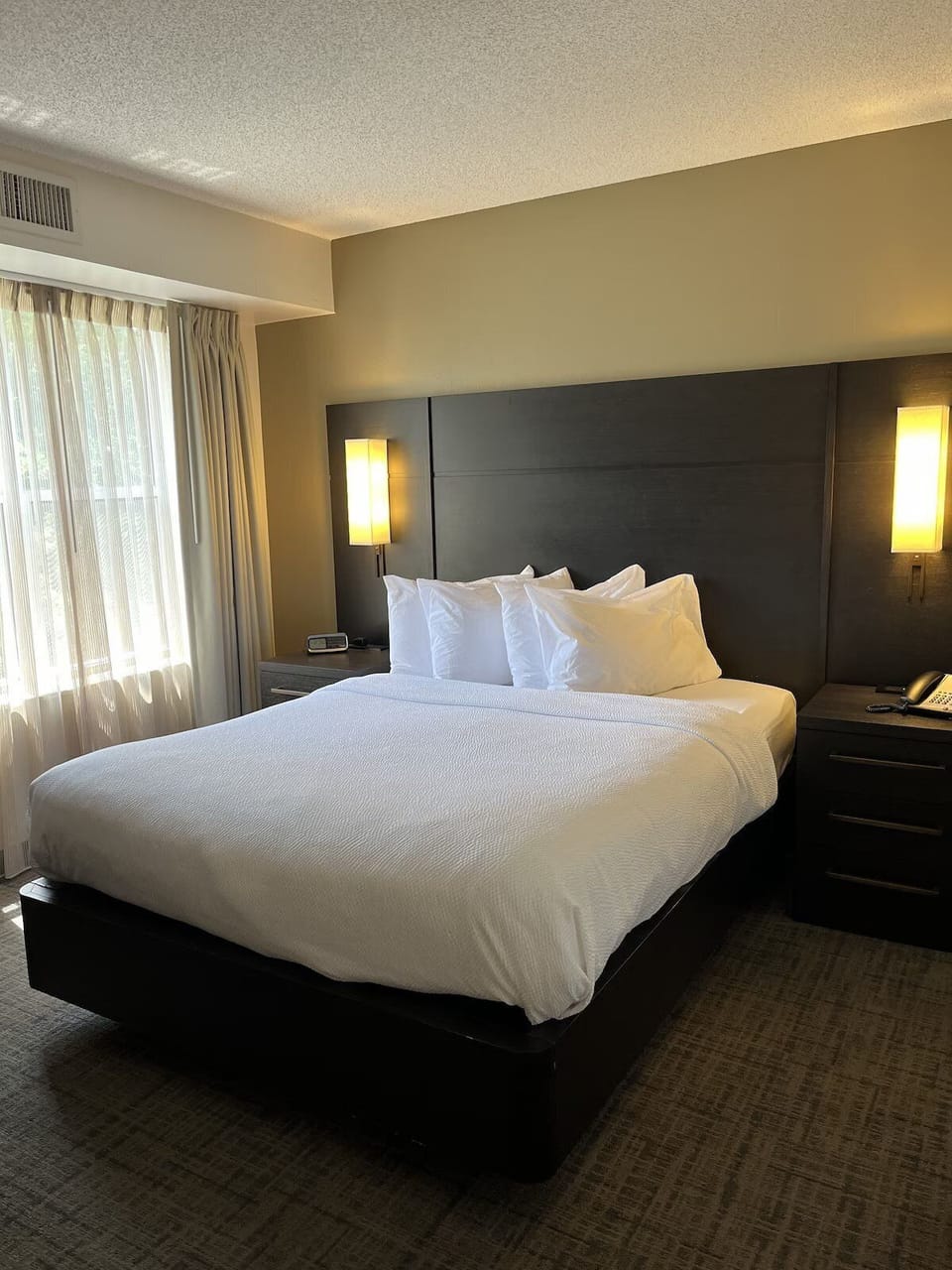 Recharge in a cozy, calming bedroom with warm bedside lighting.