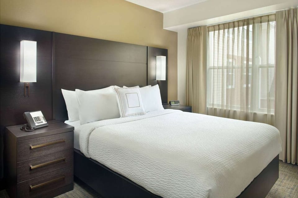 Unwind in crisp linens beside a sunlit, peaceful window.