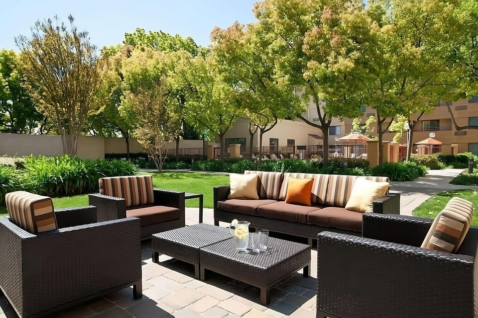 Sip morning coffee outdoors in a calm, shaded courtyard.