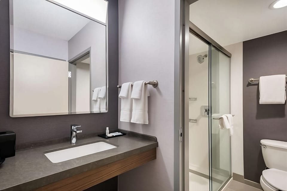 Refresh in a spotless bath with glass shower and bright vanity.