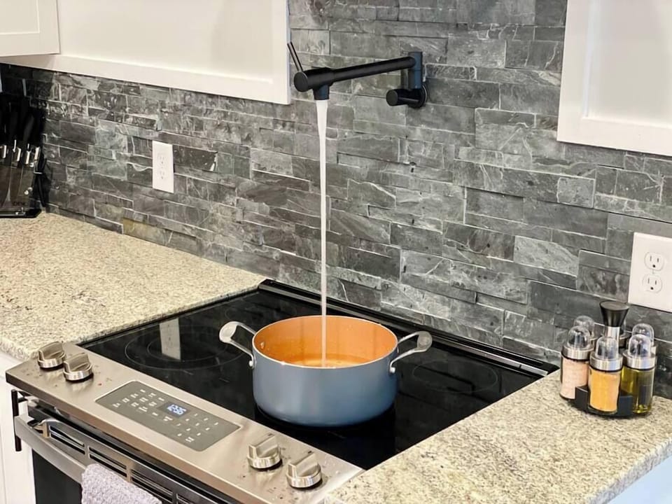 Pot filler in fully stocked kitchen with full size appliances
