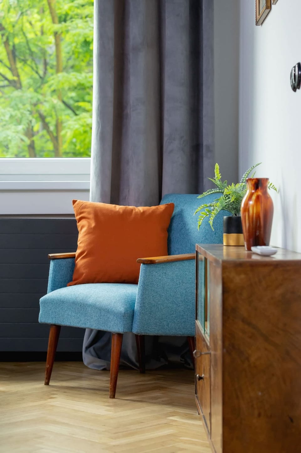 Comfortable blue armchair with soft orange cushion.