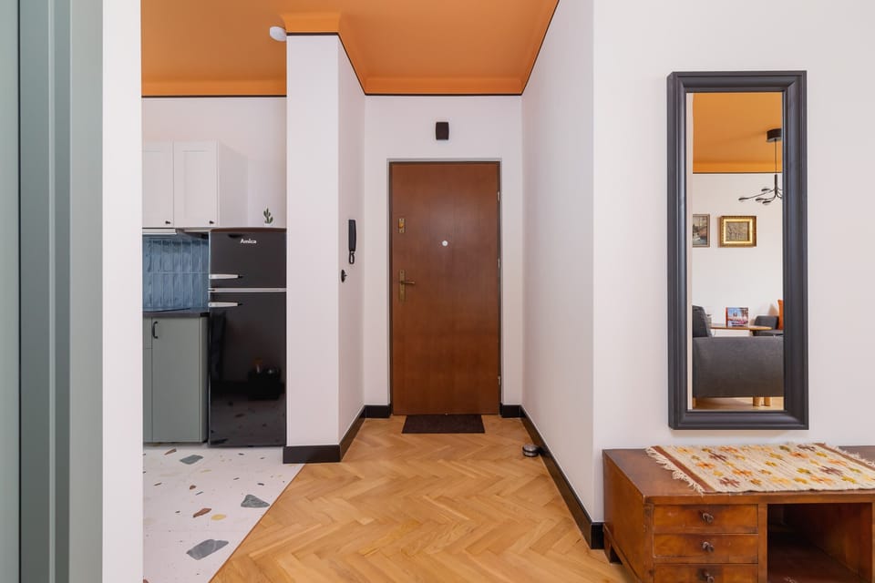 A hallway area leading to other rooms in the apartment, showcasing clean lines, a wooden floor, and a functional layout.