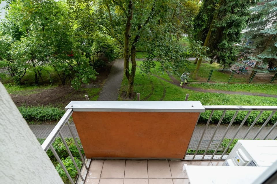 A view of the exterior balcony with seating, surrounded by greenery. The perfect spot for relaxation.