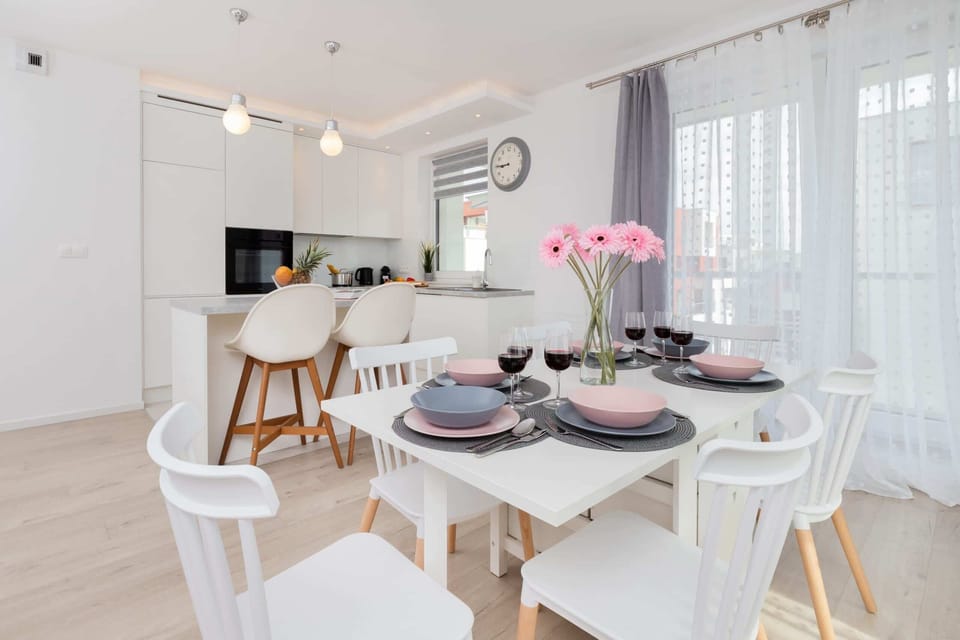 A minimalist dining setup with simple decor and a clean, sleek white kitchen in the background. Perfect for a small group or family.