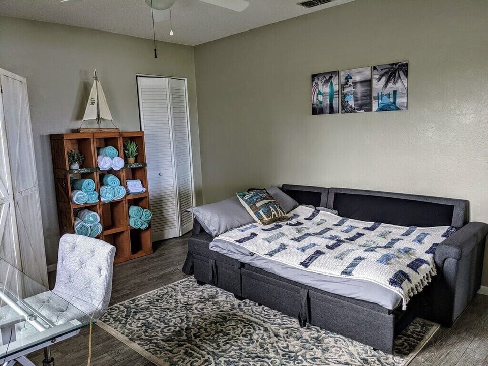 This area features a comfortable gray sofa bed, offering additional seating during the day and transforming into a cozy sleeping space at night.