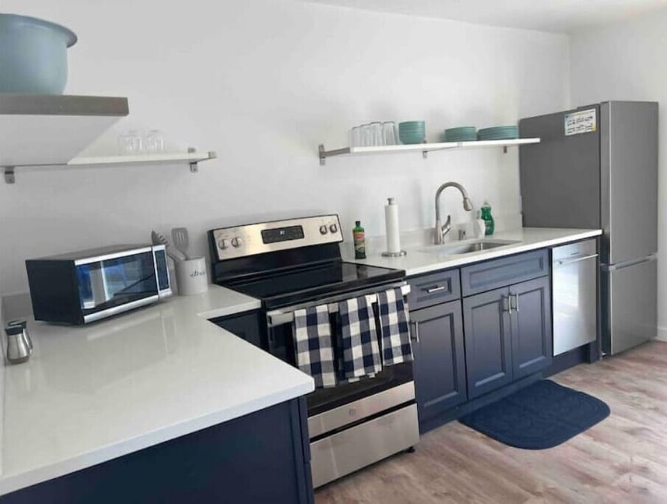 Newly renovated kitchen has stove, fridge & freezer, microwave and dishwasher.
