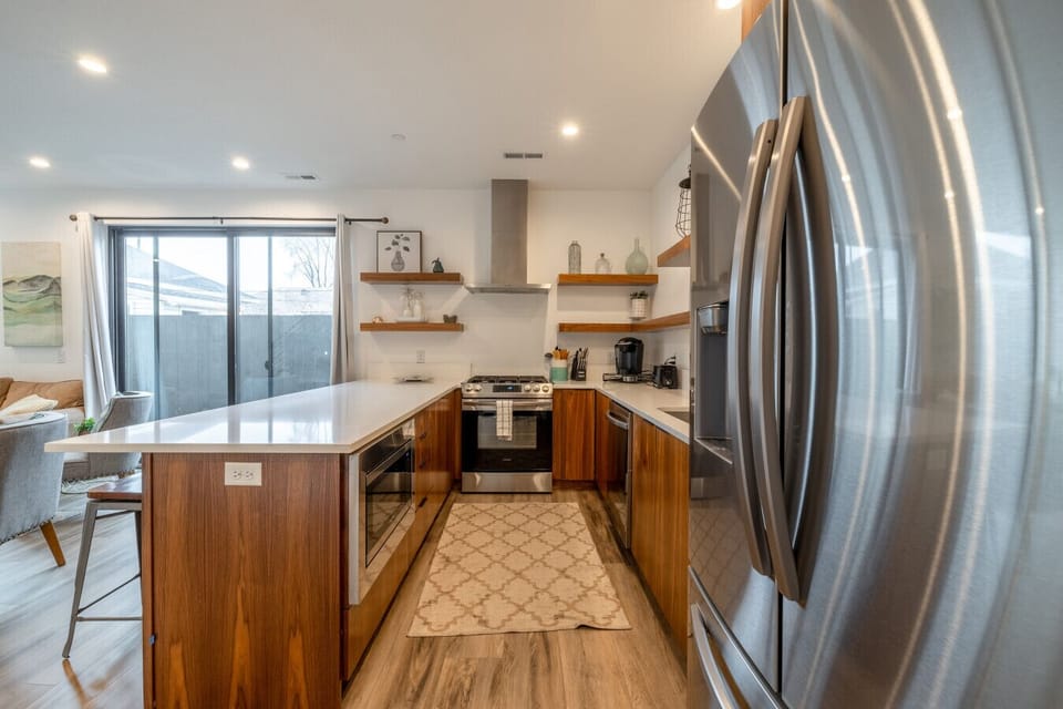 Modern kitchen with stainless steel fridge and large windows