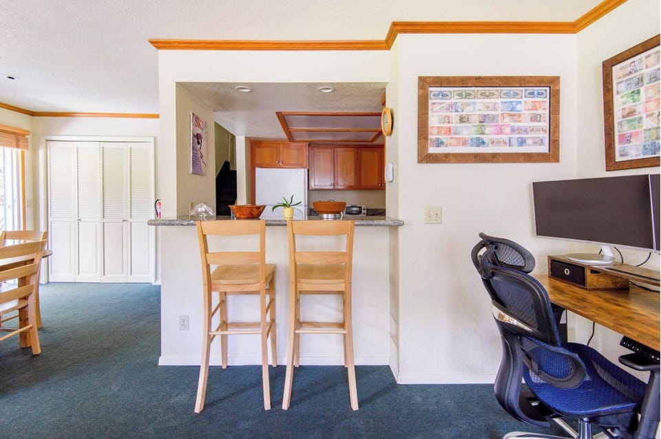 Breakfast bar and office space with ergonomic chair and two monitors. 