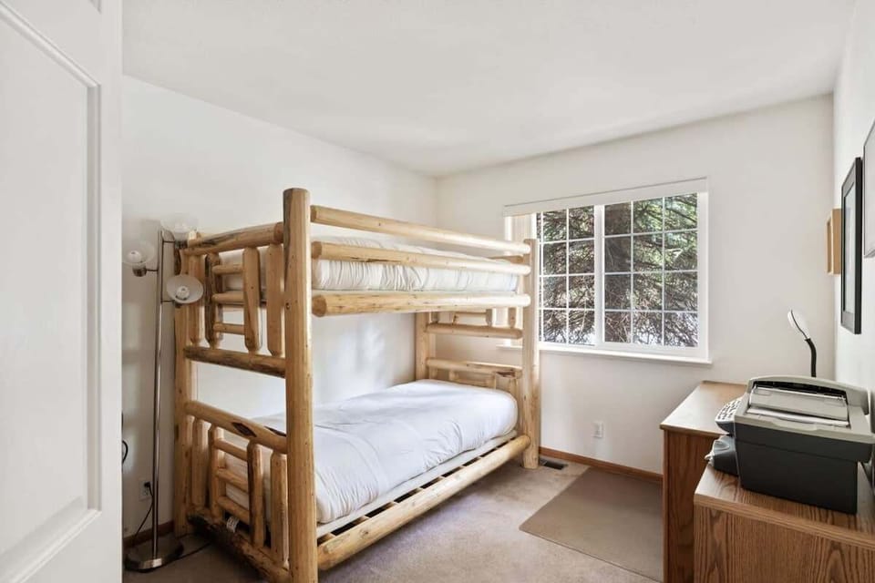 The third bedroom features a twin-over-twin bunk bed and a desk with a printer for a quiet workspace.
