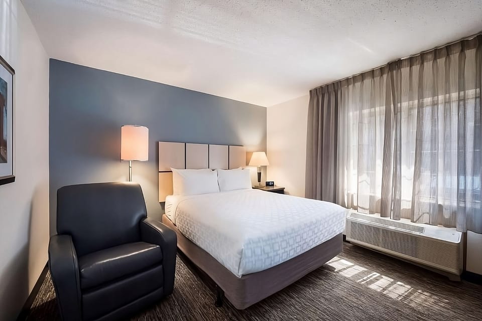 Unwind in a bright, plush bed beside sunny windows.