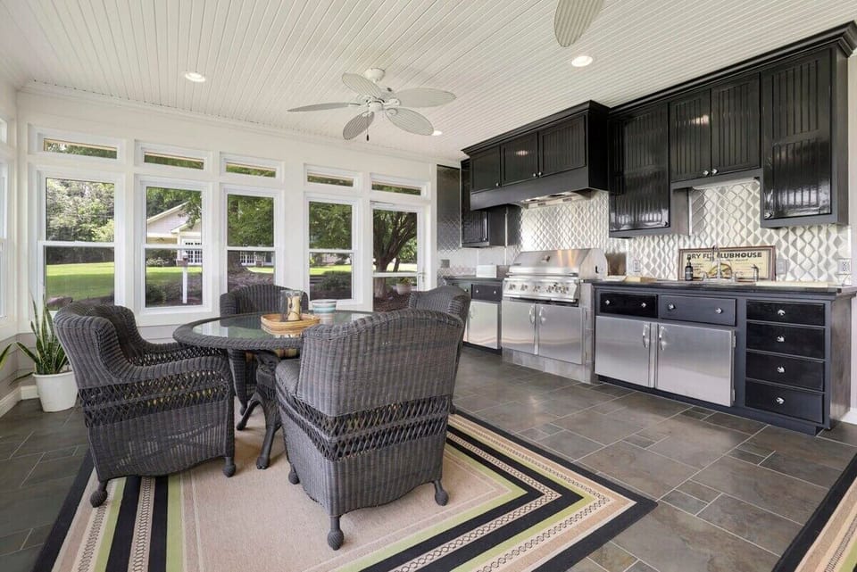 To the left, you'll see our 4-top dining table and to the right, you'll have access to our indoor grilling area, where you'll find a propane grill and fully stocked kitchenette.