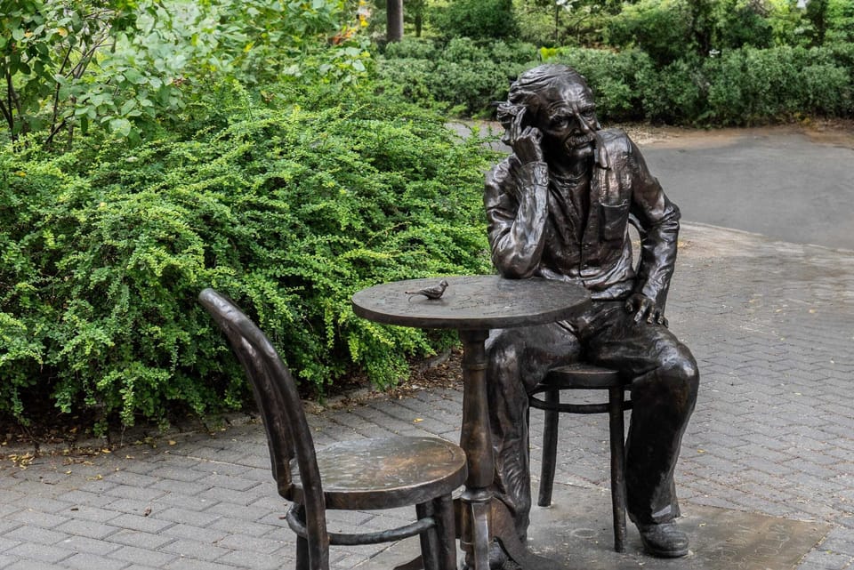A local landmark featuring a statue of a figure seated at a table, adding cultural interest to the surroundings.
