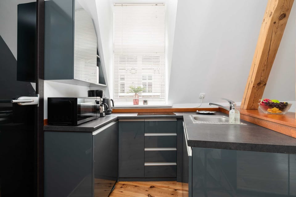 A modern kitchenette equipped with dark cabinets, a sink, and ample counter space, blending functionality with style.
