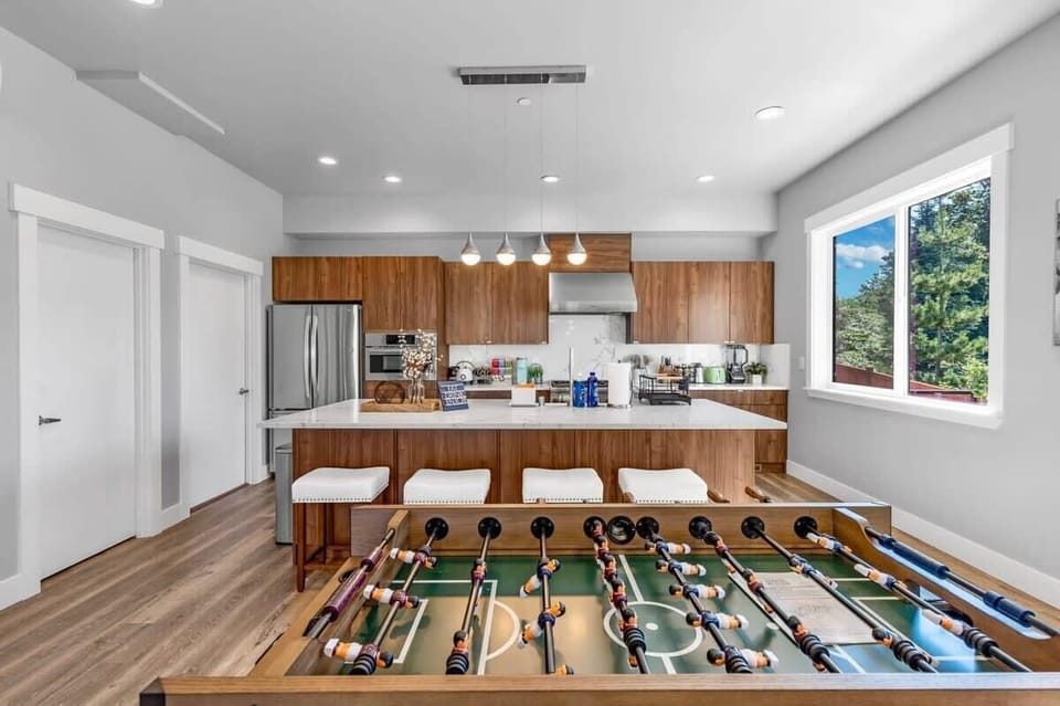 Luxury kitchen with a foosball table next to it.