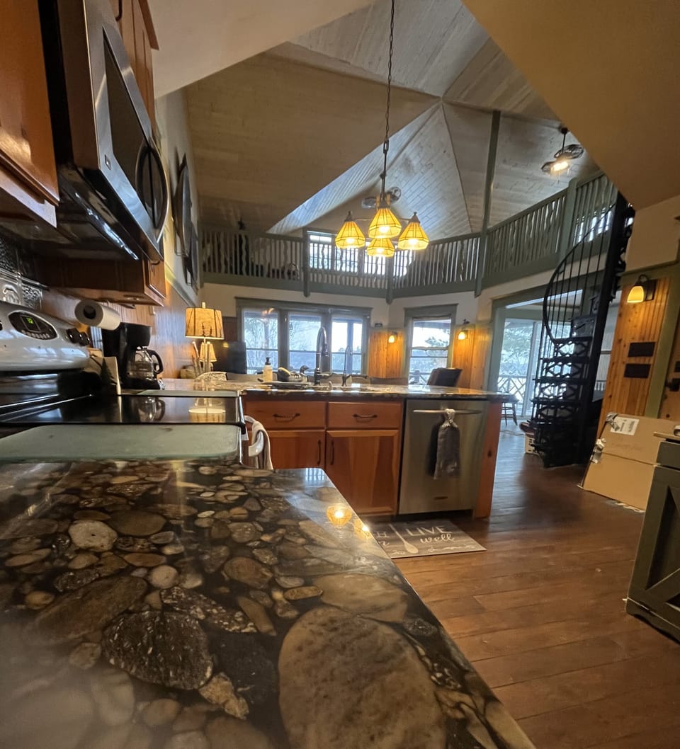 Open layout kitchen with custom river rock bottom granite countertops