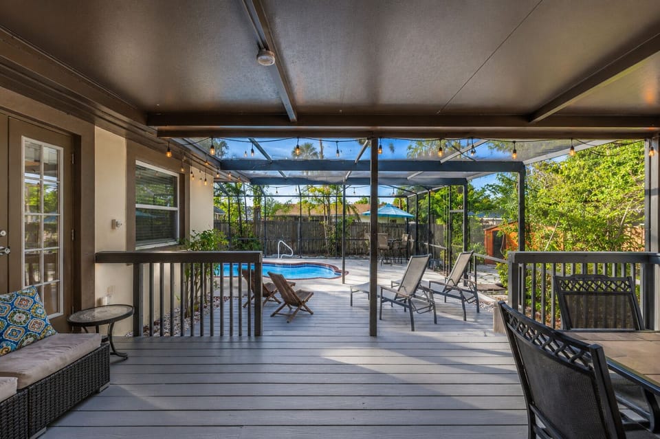 Spacious screened patio with cozy seating areas and relaxing poolside views.