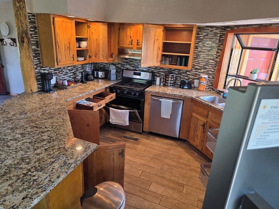 Full kitchen with granite counters and stainless appliances.